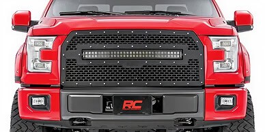 Bold red pickup truck front grille with black detailing and LED lighting accents.