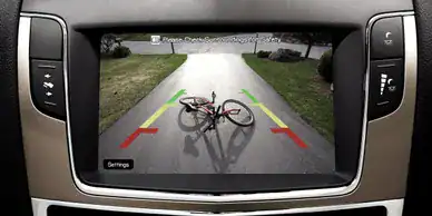 Bicycle lying on street in front of car's rearview camera.