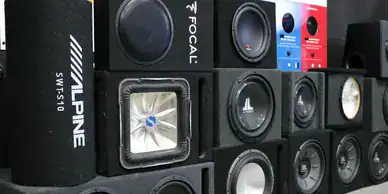 High-quality array of various black, red, and blue speakers stacked together.
