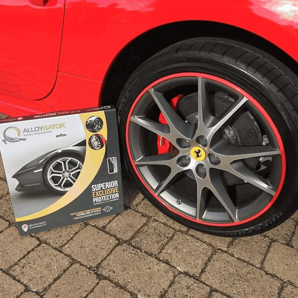 Alloy wheel and brake caliper close-up on red sports car with protective wheel cover box.